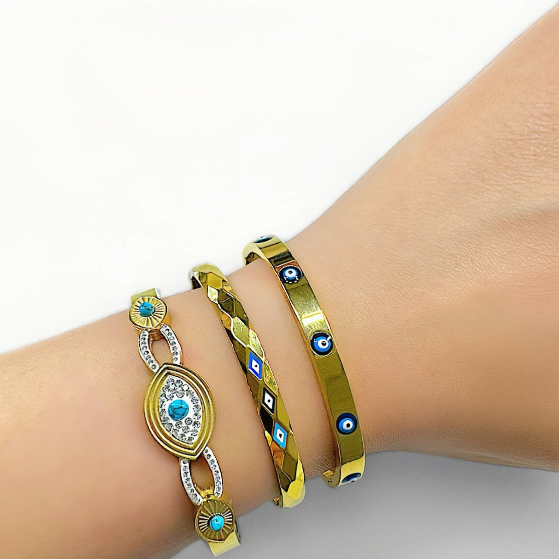 Stijlvolle gouden armband van roestvrij staal met drie boze oog symbolen in verschillende blauwe tinten, biedt bescherming en een trendy look, perfect voor dagelijks gebruik