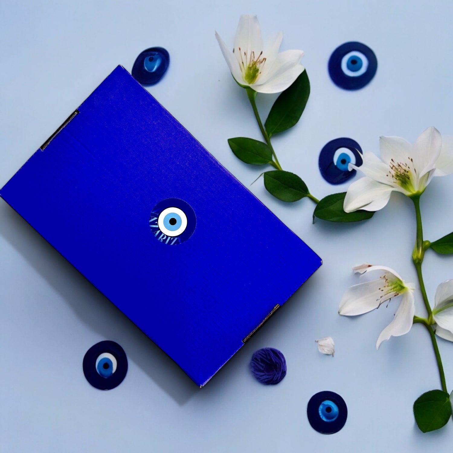Complete beauty & ontspanning cadeaubox van Nazarize met Nazar Focus make-up en toilettas, Nazar Aesthetic Boze Oog nagelstickers, zwarte Nazar Boze Oog scrunchie, en blauwe Nazar Boze Oog Blue Sky scrunchie haarband. Perfect als luxe geschenk voor pure verwennerij en ontspanning.