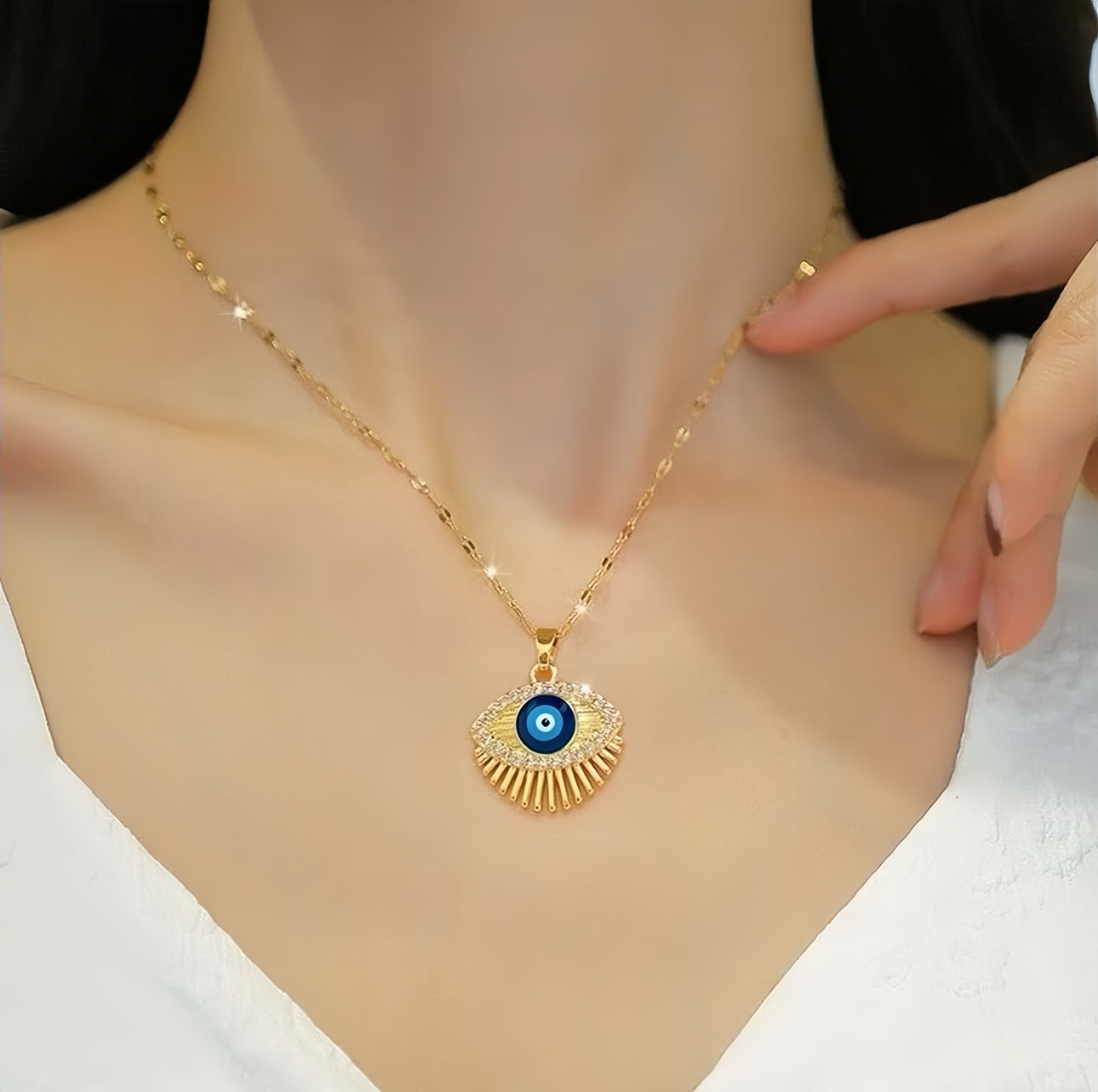 Model draagt de Boze Oog Moonlit ketting in goud, gecombineerd met een casual outfit, benadrukt het tijdloze en beschermende ontwerp