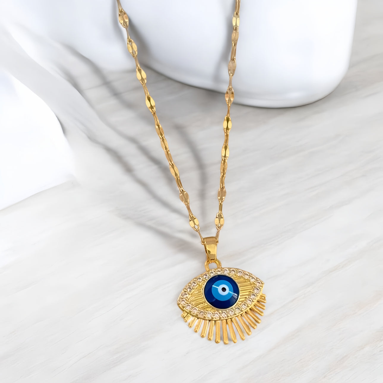 De Boze Oog Moonlit ketting in goud, getoond op een witte achtergrond, een elegant design